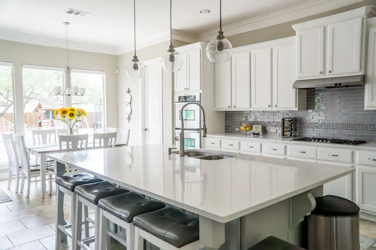 A bright kitchen with white cabinets and an island
